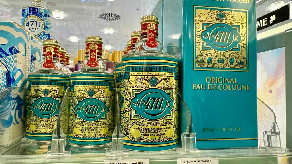 Test-4711-Parfum: Mehrere Parfumflaschen in unterschiedlichen Größen stehen in einem Regal.