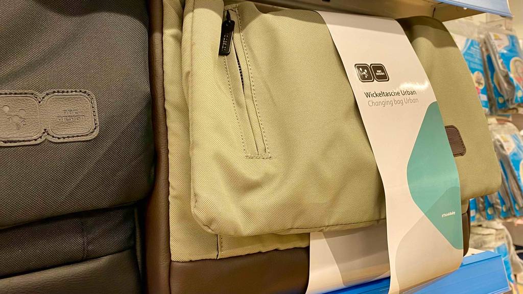 Eine getestete Wickeltasche neben anderen Produkten im Regal.