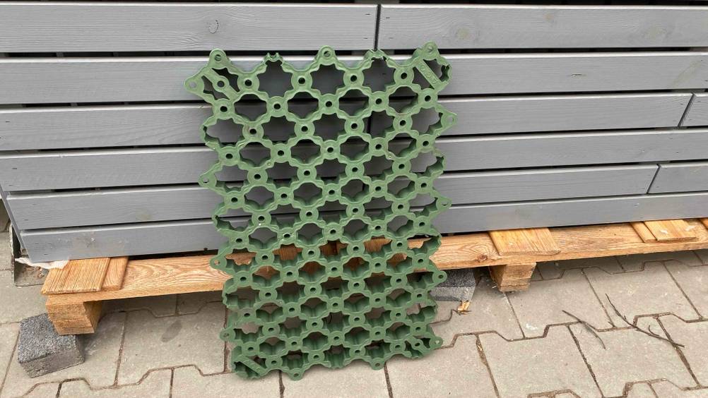 Rasengitter im Test: Ein grünes Rasengitter ist an einer Palette angelehnt.