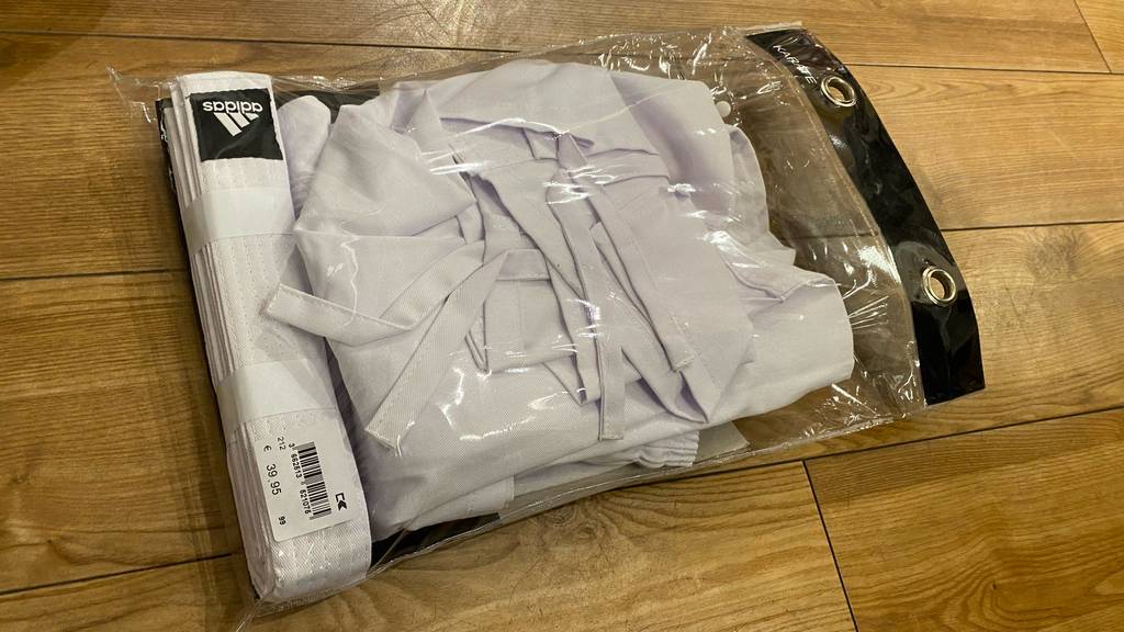 Karateanzug getestet: Karateanzug in Verpackung mit Preisschild darauf liegend auf einem Boden.