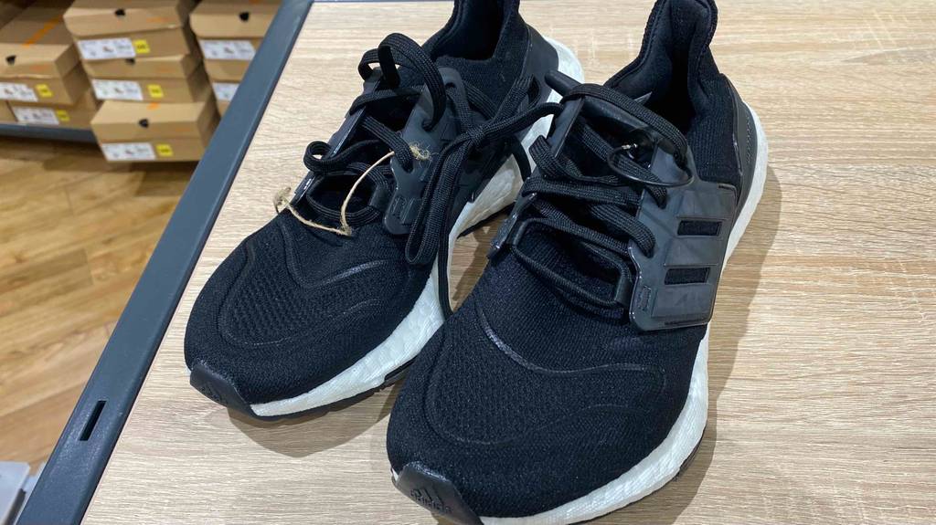Adidas-Ultra-Boost getestet: ein Paar schwarze Schuhe mit Schnürsenkeln stehen nebeneinander in einem Geschäft.