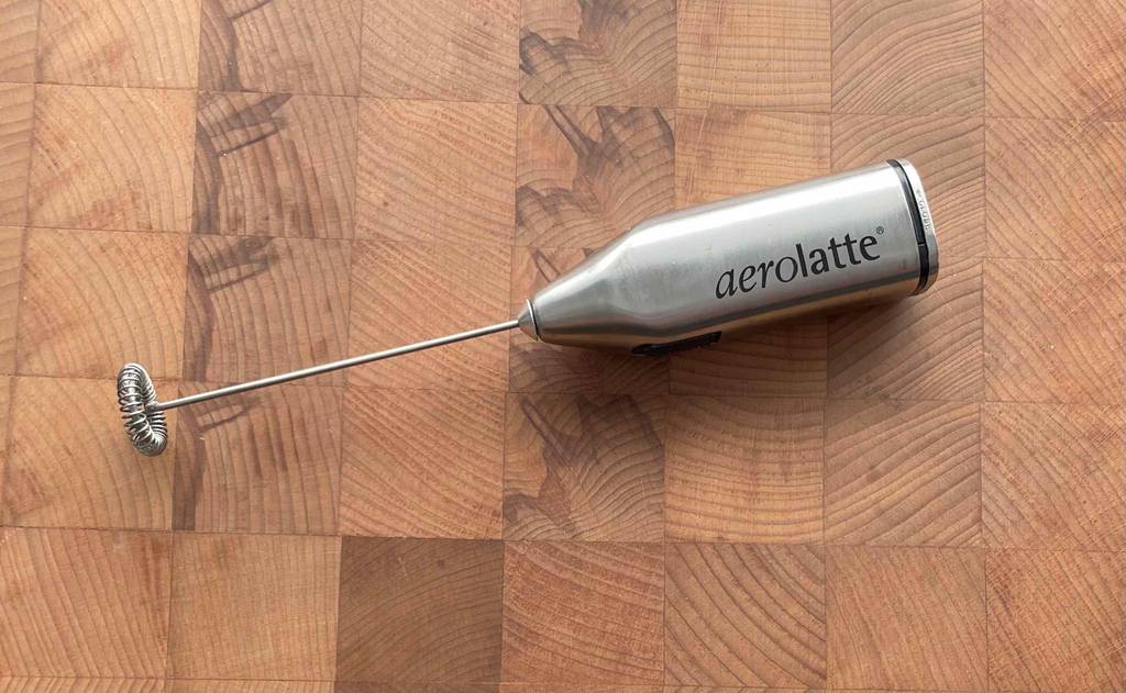 Ein getesteter Stab-Milchaufschäumer liegt auf einer Holzoberfläche