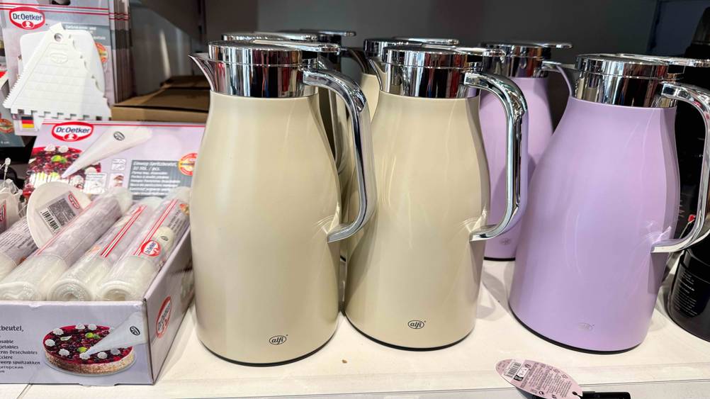 Mehrere getestete Alfi-Isolierkannen stehen in der Farbe Beige und Lila in einem Geschäft.