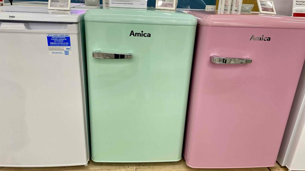 Retro-Kühlschrank-Test: ein rosafarbiger Retro-Kühlschrank steht neben türkisfarbigen und weißen Modell in einem Geschäft.