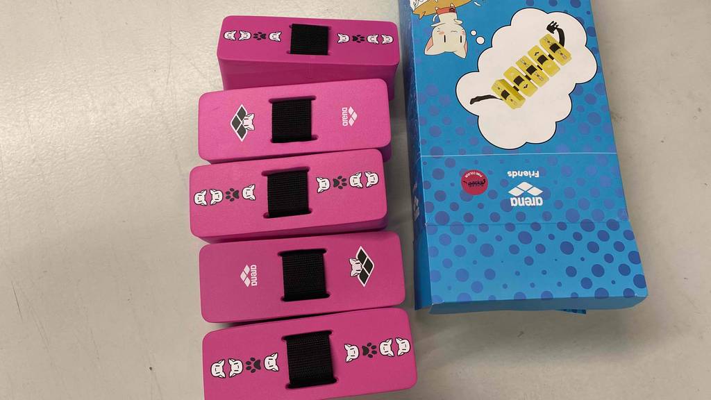 Rosa Schwimmgürtel neben Verpackung.