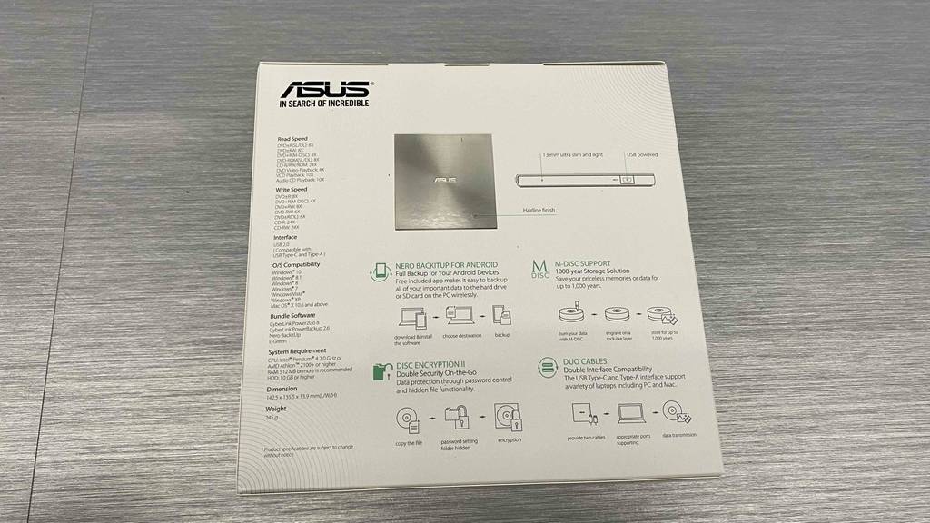 DVD-Brenner von asus getestet: Eine Originalverpackung mit der Rückseite nach oben auf einem grauen Boden.