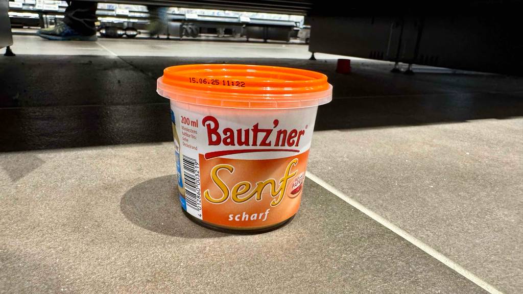 Getesteter scharfer Senf steht in einem Geschäft auf dem Boden.