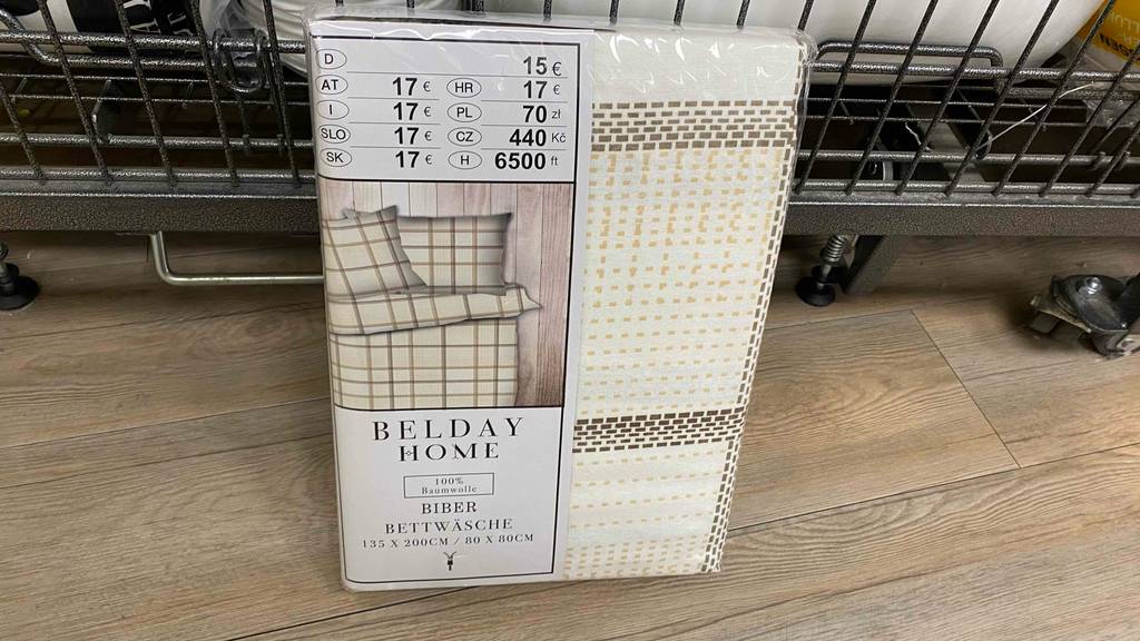 Eine getestete Biber-Bettwäsche in Originalverpackung lehnt an einem Regal.