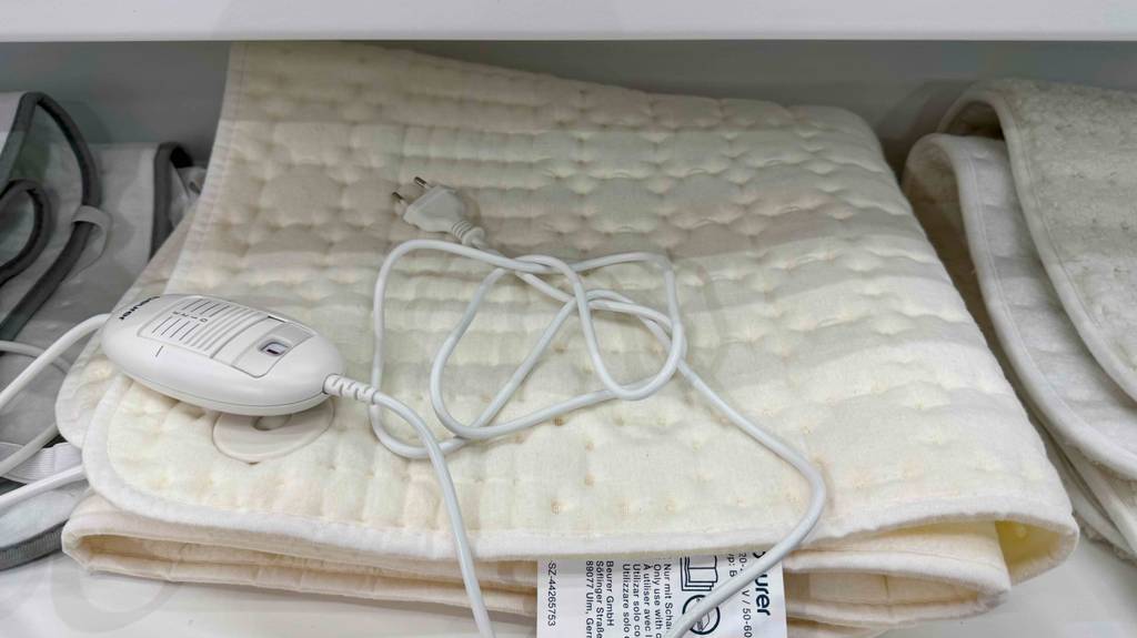 Das beigefarbene getestete Beurer-Wärmeunterbett liegt zusammengefaltet auf einem Verkaufsregal.