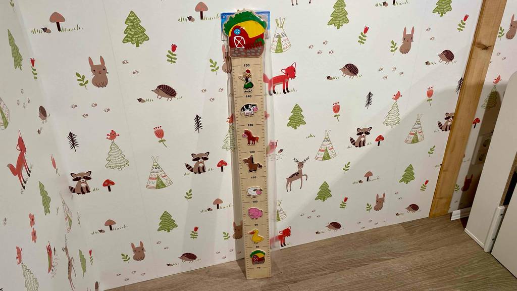Messlatte-Kinder getestet: gesamte Messlatte an einer dekorativen Wand angelehnt.