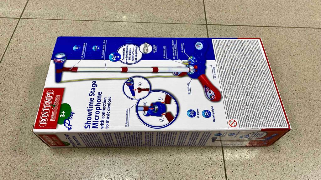 Kinder-Mikrofon-Test: Verpackung von Kinder-Mikrofon mit Standfuß liegt auf einem Boden.