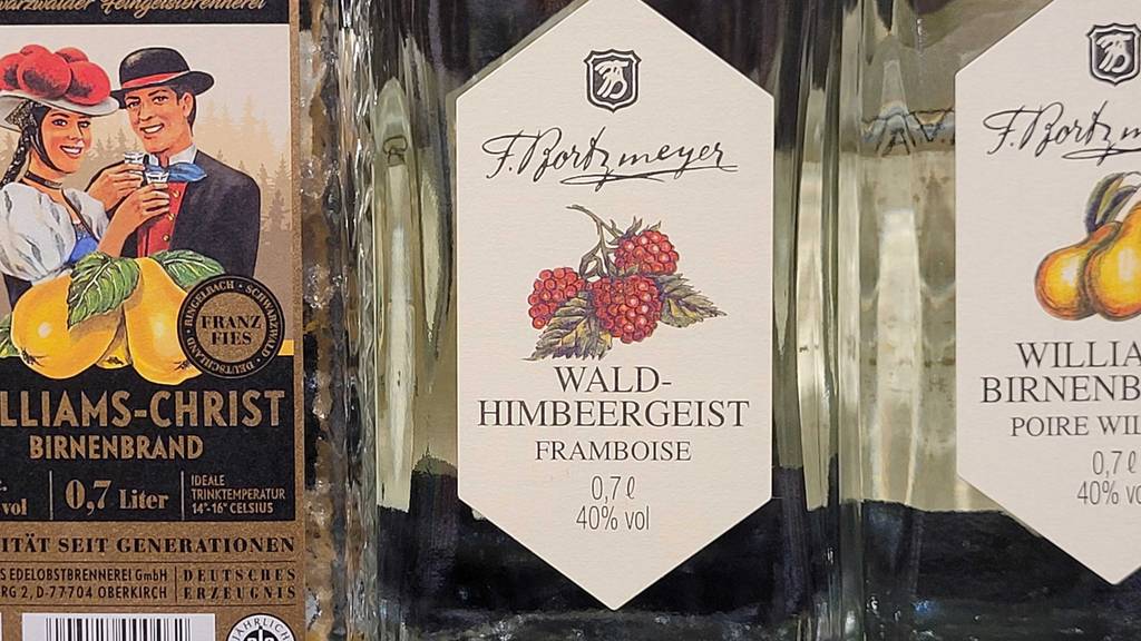 Himbeerlikör im Test: Nahaufnahme des Etiketts mit Herstellerangaben auf einer transparenten Flasche mit 40-prozentigem Wald-Himbeergeist.