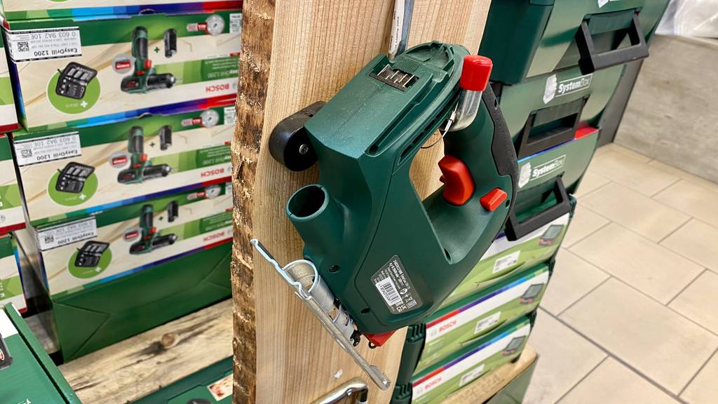 Bosch-Stichsäge im Test: Bosch-Stichsäge ist an einem Holz befestigt vor Verpackungen in einem Geschäft.
