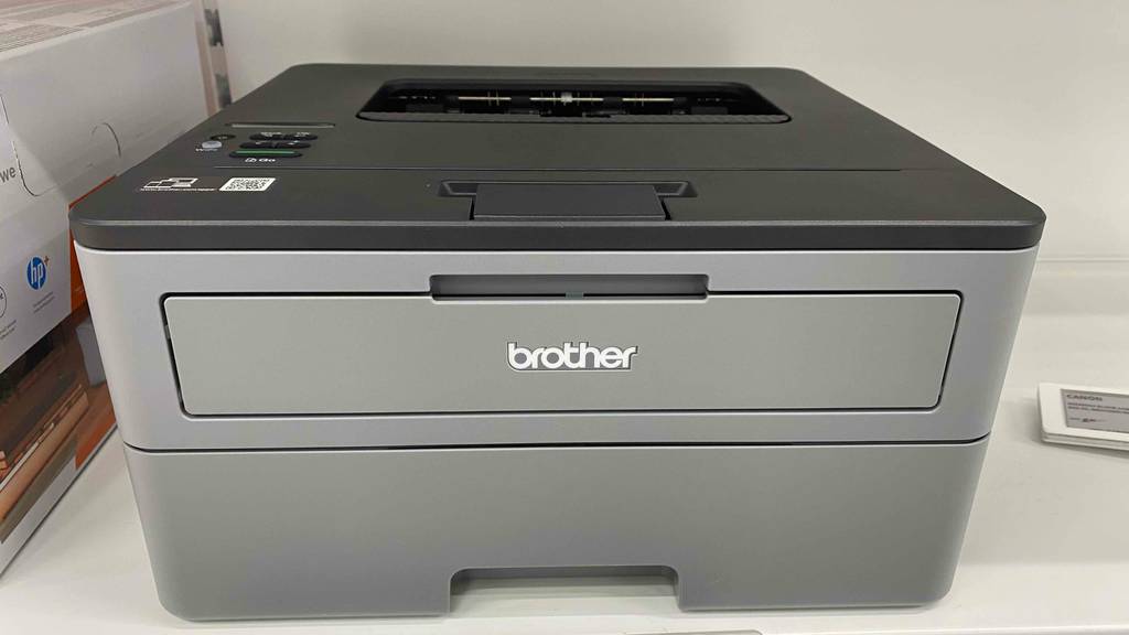 Brother-Farblaserdrucker-Test: Brother-Farblaserdrucker von vorn in einem regal stehend.