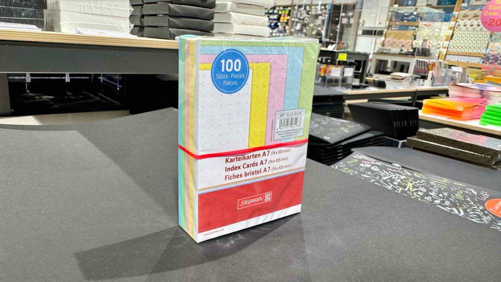 Bunte Karteikarten, die getestet wurden, stehen schräg in einer Schreibtischunterlage.
