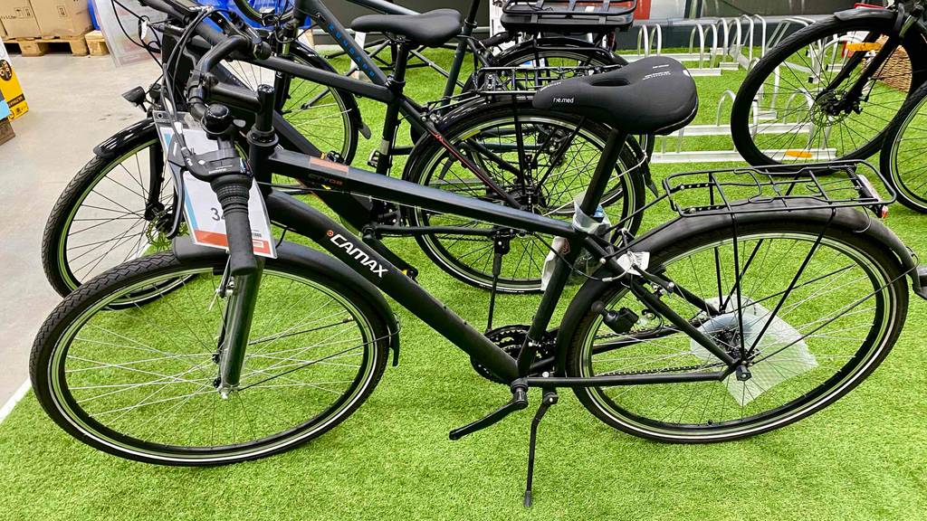 Trekkingrad im Test: ein Trekkingrad steht auf dem Ständer neben anderen Fahrrädern in einem Geschäft.