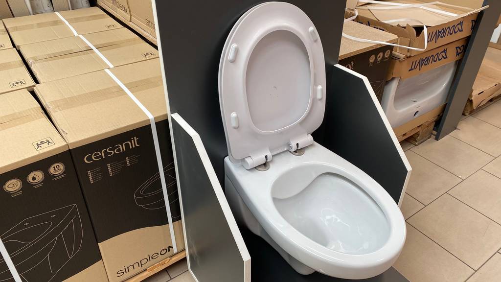 In einer Austellungsfläche steht ein getestetes Wand-WC montiert, mit geöffnetem Deckel.