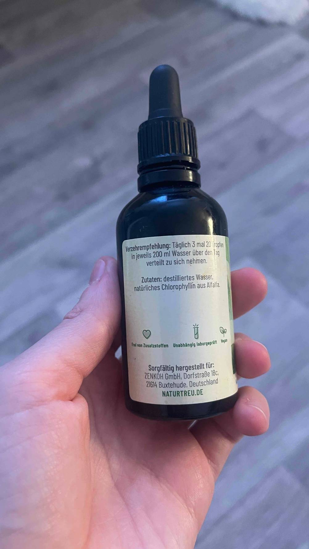 Chlorophyll-Tropfen-Test: Das Fläschchen wird in der Hand gehalten, während die Verzehrempfehlung und andere Informationen zum Produkt ersichtlich sind.