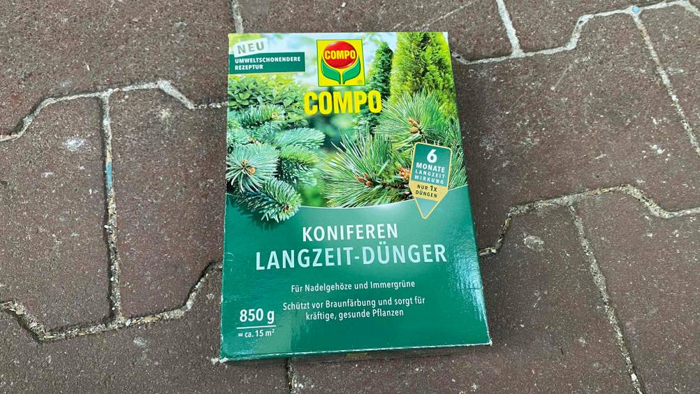 Koniferendünger im Test: Eine Packung liegt auf einem Pflasterboden