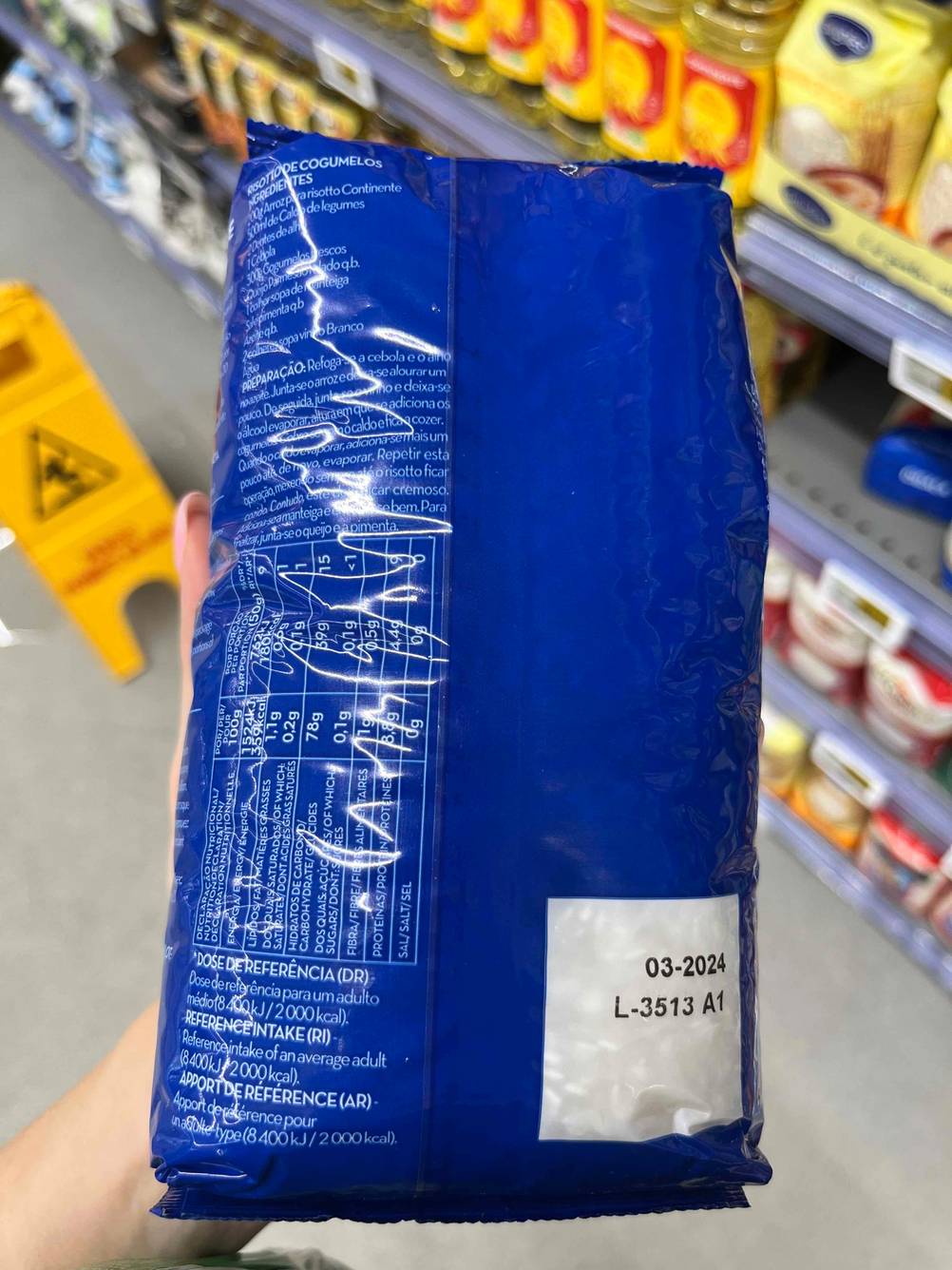 Risotto-Reis im Test: Verpackung wird vor einem Regal gehalten, mit Blick auf die Rückseite.
