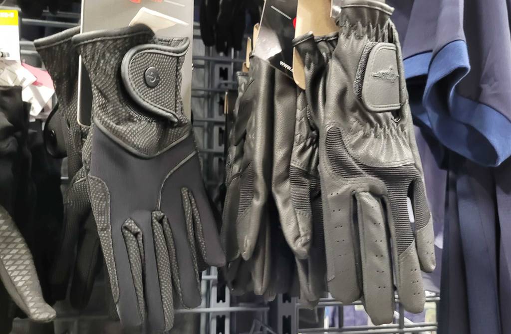 Reithandschuhe-Test: Mehrere Paar getestete Reithandschuhe hängen in einem Regal.