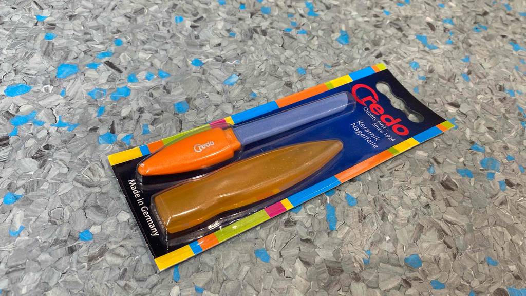 Keramik-Nagelfeile-Test: Keramik-Nagelfeile mit orangefarbenen Griff und Schutzkappe in Verpackung.