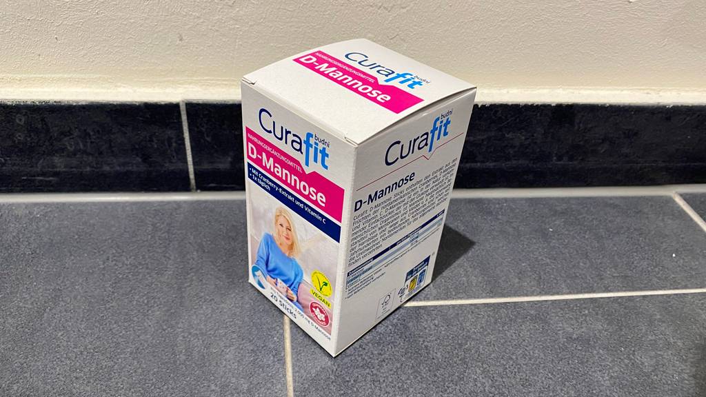 Eine Packung getestete D-Mannose von schräg oben auf einem Fließenboden