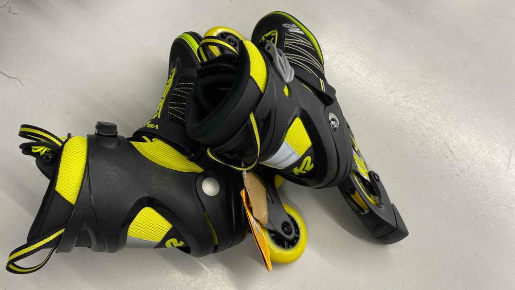 Inline-Skates-Herren im Test: schwarz-gelbe Inline-Skates für Herren liegen aufeinander mit schwarzer Bremse.