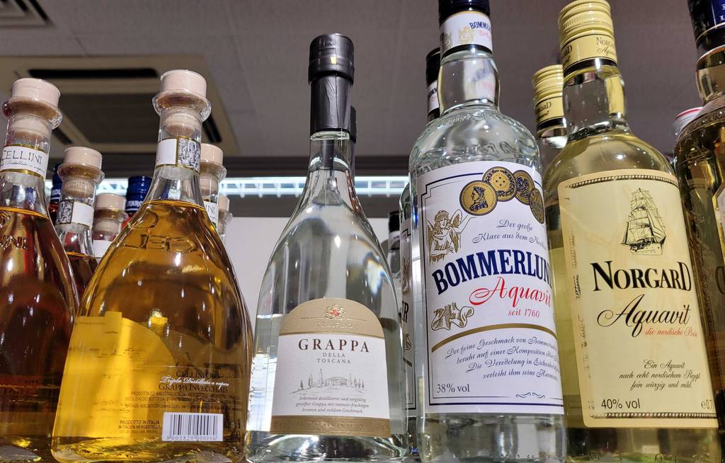 Grappa getestet: eine Flasche Grappa steht neben anderen alkoholischen Getränken in einem Regal.
