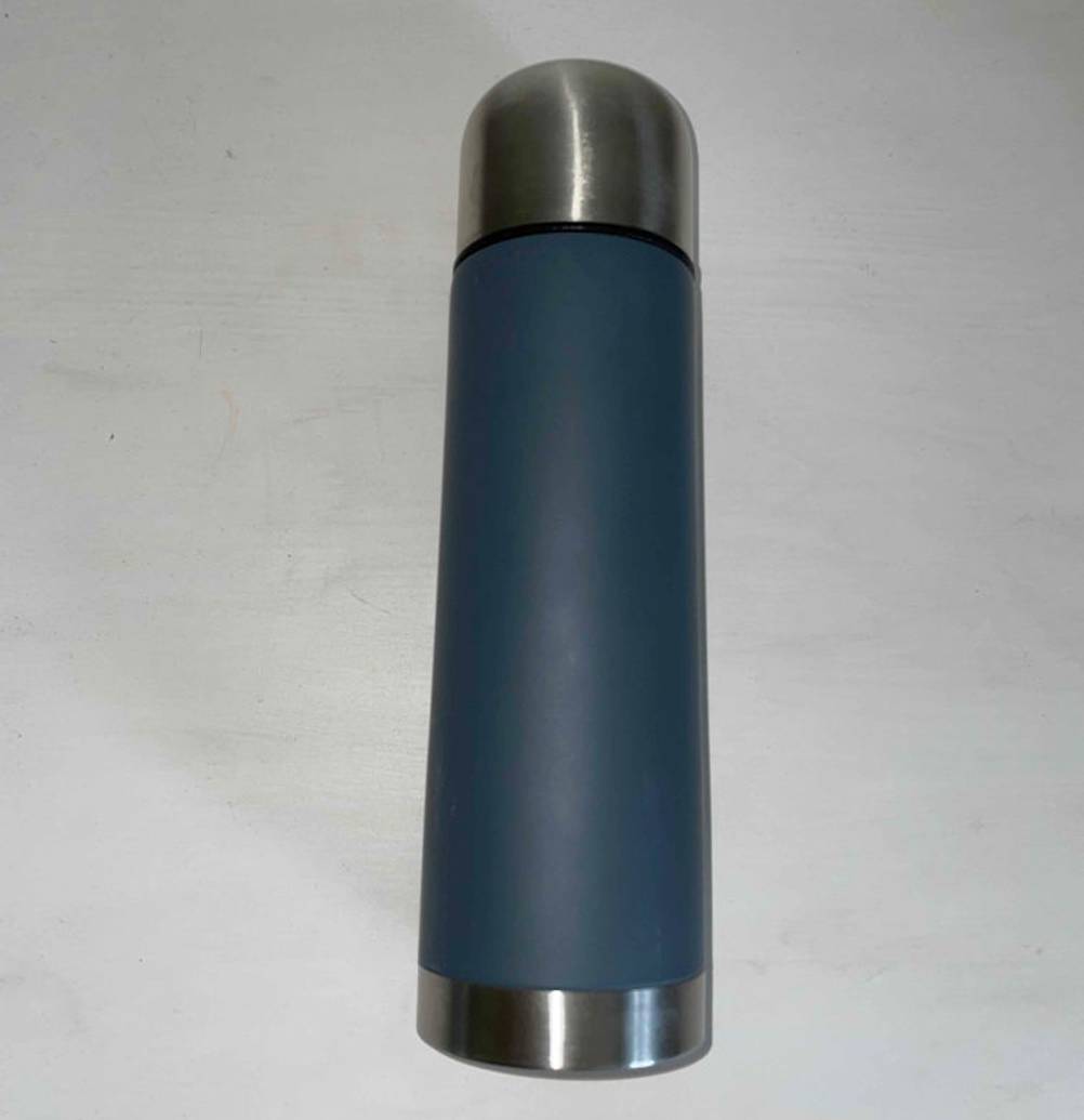 Thermosflasche im Test: eine verschlossene Thermosflasche liegend auf einer weißen Fläche.