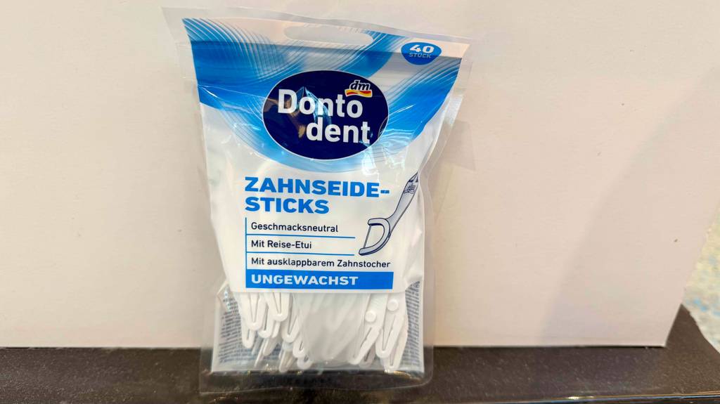 Eine Packung Zahnseide-Sticks steht vor einem weißen Hintergrund.