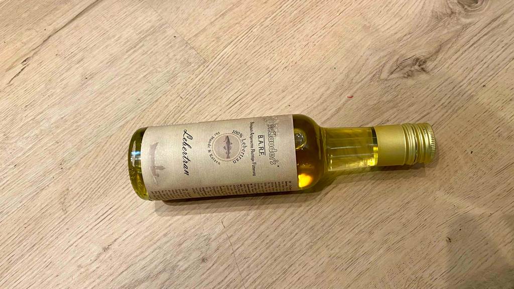 Lebertran im Test: eine Flasche Lebertran liegend auf einer Holzfläche.
