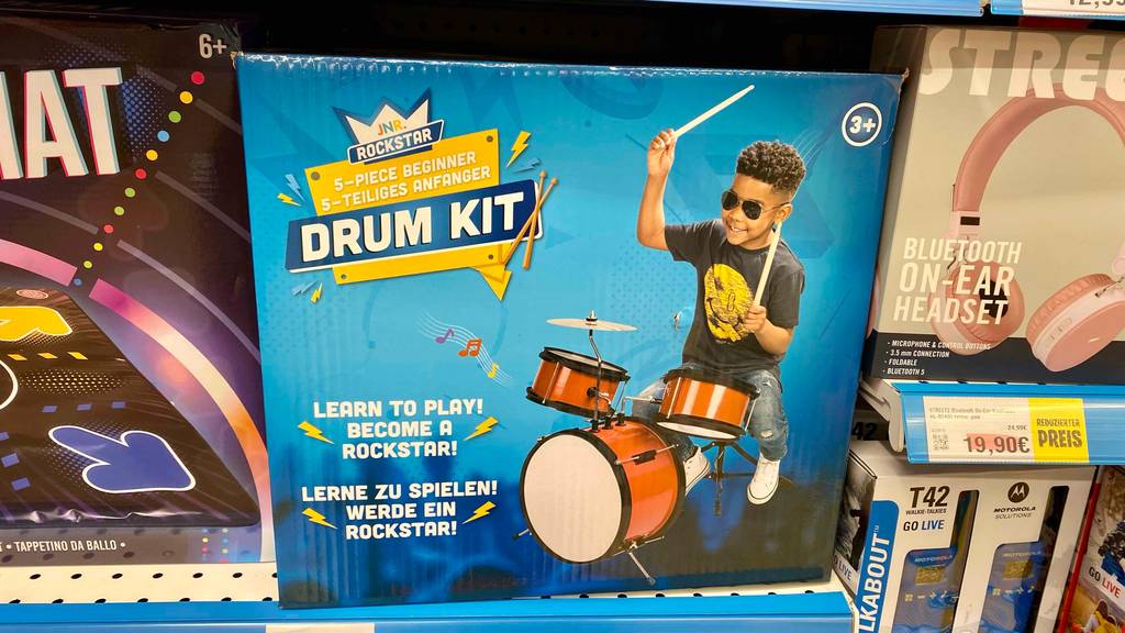 Ein getestetes Kinderschlagzeuge steht neben anderen Produkten im Regal.