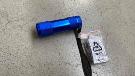 LED-Taschenlampe im Test: Blaue LED-Taschenlampe liegt auf einem grauen Boden
