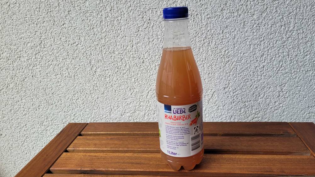 Rhababersaft im Test: eine verschlossene Flasche Rhababersaft auf einem Holztisch stehend.