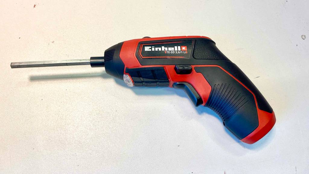 Ein getesteter Einhell-Akkuschrauber auf einer weißen Fläche liegend.