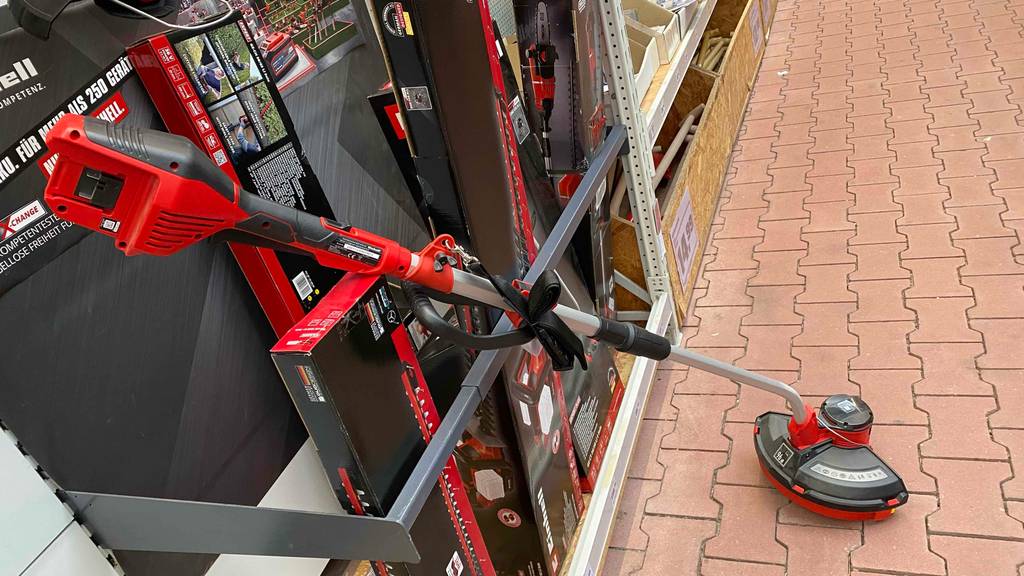 Einhell-Rasentrimmer getestet: gesamter Einhell-Rasentrimmer mit Stange an einem Regal angelehnt.