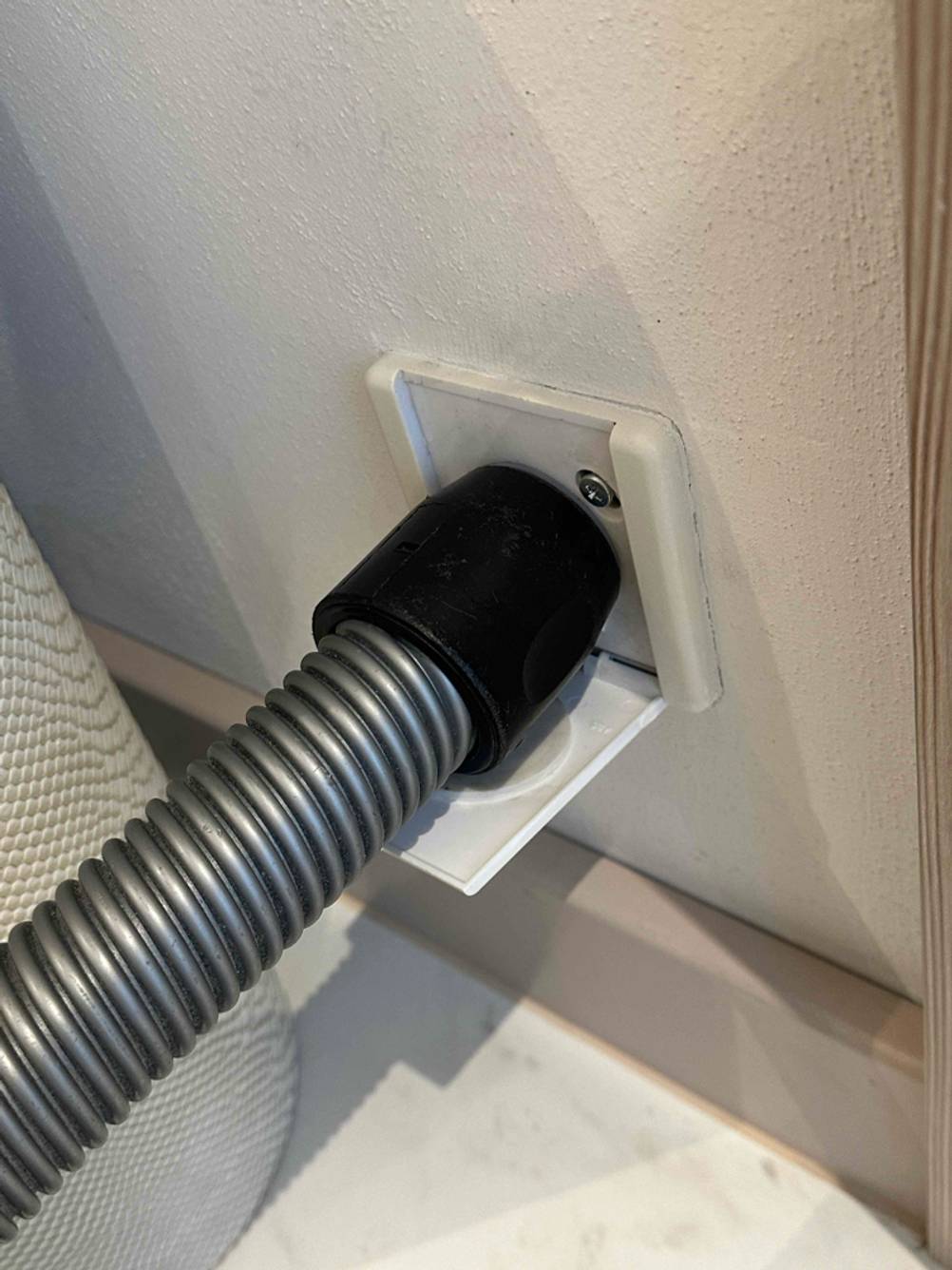 Angeschlossenes Rohr eines getesteten Zentralstaubsaugers in Nahaufnahme.