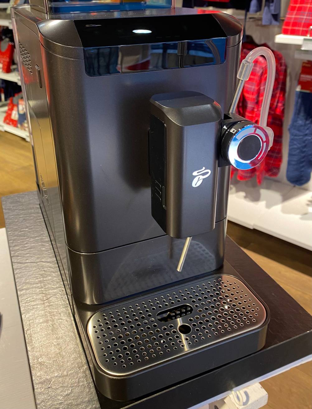 Ein getesteter Melitta-Kaffeevollautomat von schräg vorne auf einer dunklen Fläche.