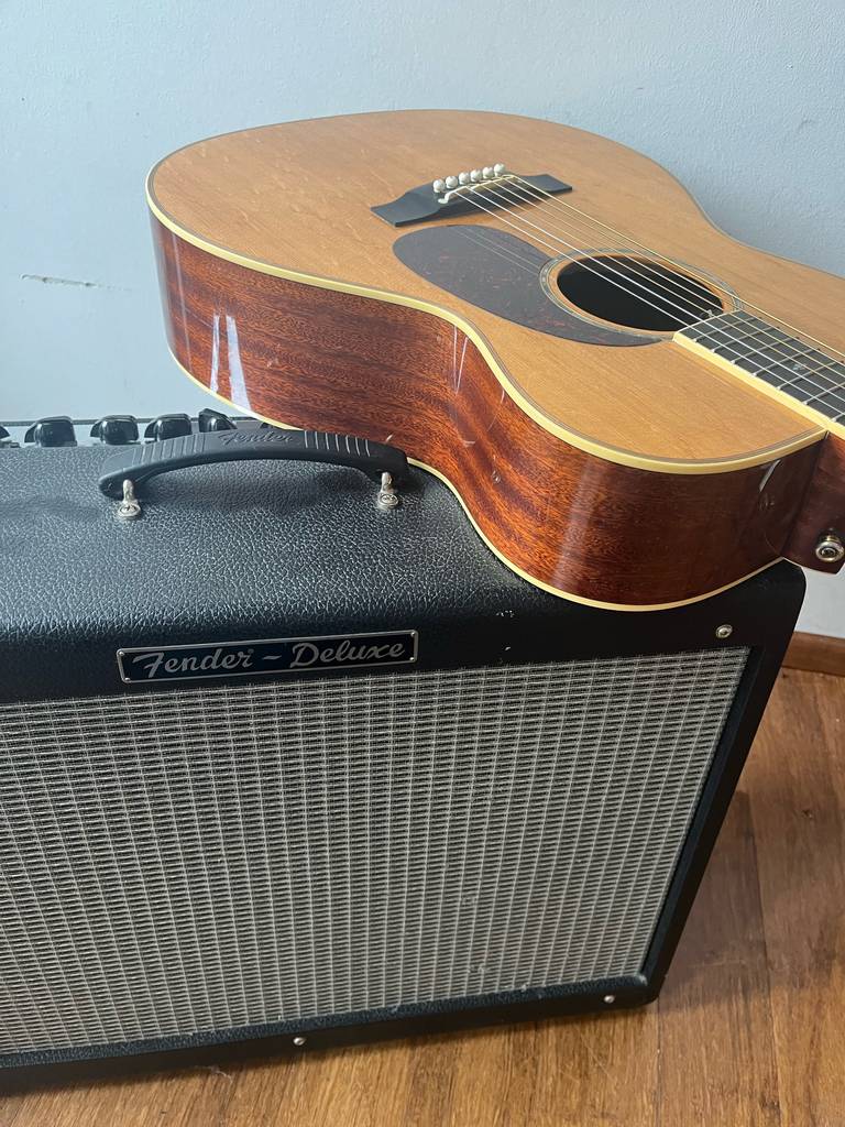 Eine Gitarre liegt auf dem getesteten Akustikgitarren-Verstärker.