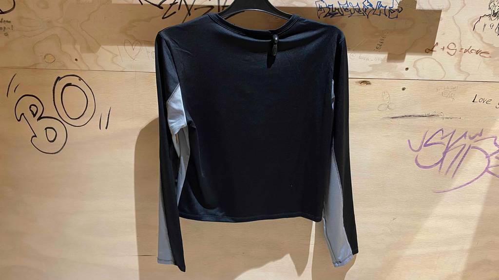 Kompressionsshirt für Damen im Test: Rückseite eines Kompressionsshirts, das auf einem Kleiderbügel hängt.