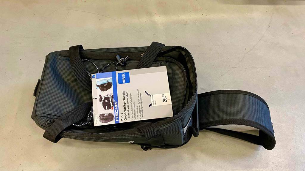 Gepäckträgertasche getestet: eine schwarze Gepäckträgertasche liegend auf einem Boden mit Etikett darauf.