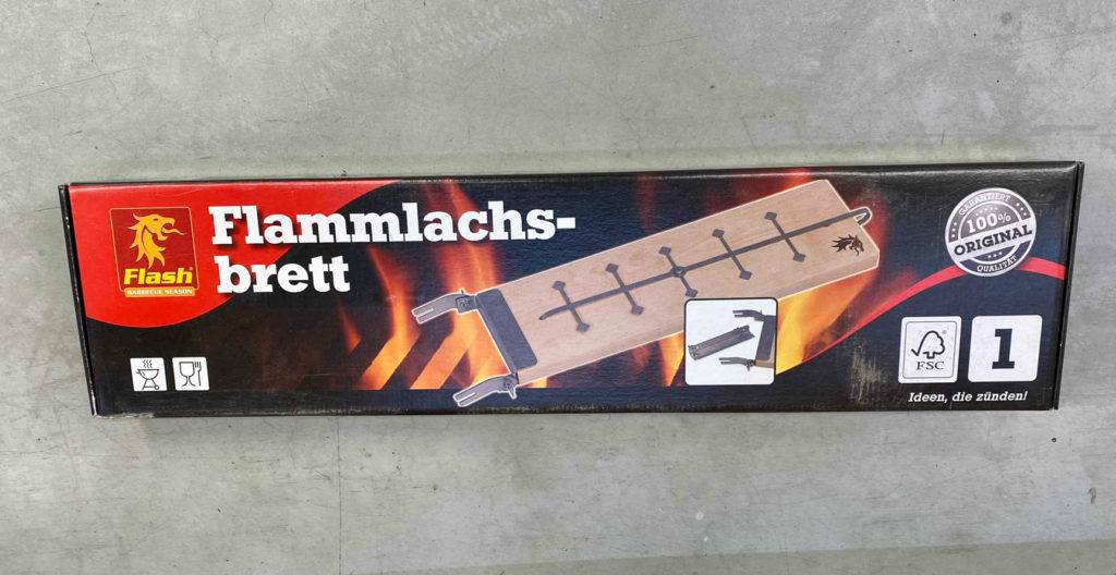 Vor einem Regal liegt ein getestetes Flammlachsbrett in Originalverpackung.