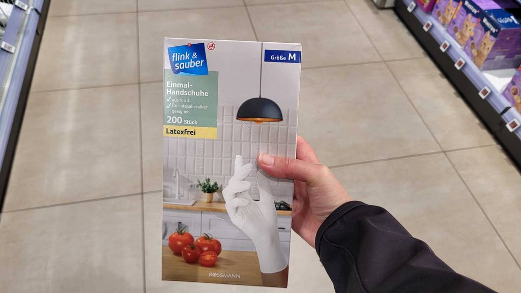 Eine Packung mit Einmalhandschuhen im Test wird in einer Hand gehalten.