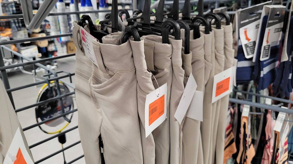 Reithose Kinder Test: Mehrere Kinder-Reithosen in der Farbe Beige hängen in einem Regal nebeneinander.