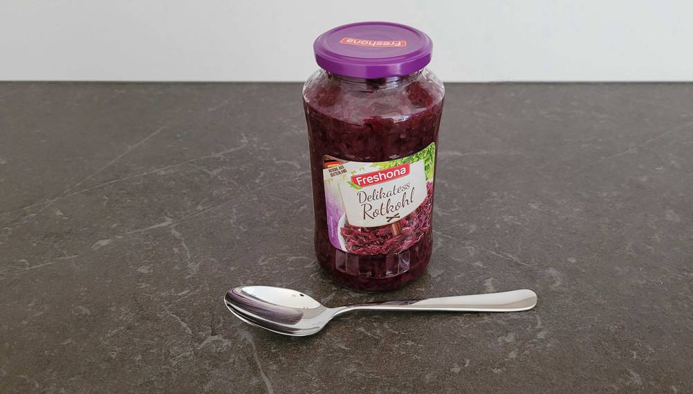 Rotkohl im Test: Ein Glas Rotkohl, davor ein Löffel auf dunklem Untergrund