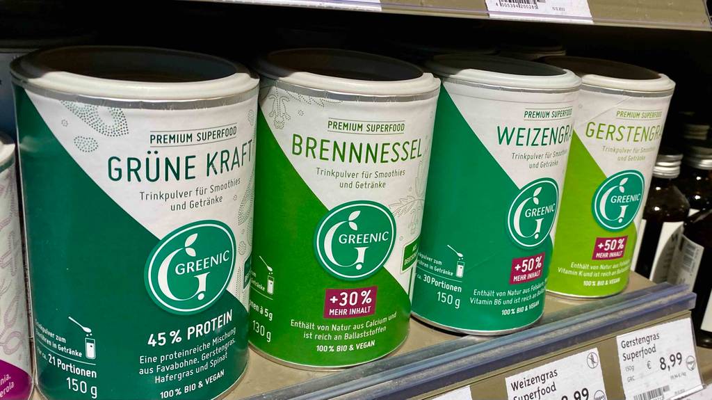 Eine Dose getestetes Weizengraspulver steht neben anderen Produkten in einem Regal.