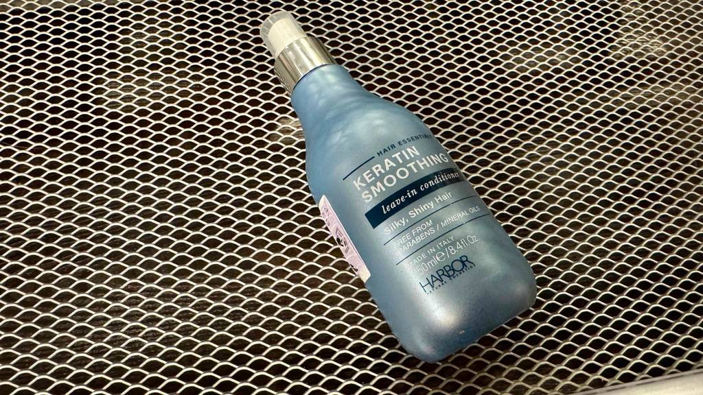 Keratin-Spülung im Test: Eine Keratin-Spülung mit Pumpspender liegt auf einem Gitter.