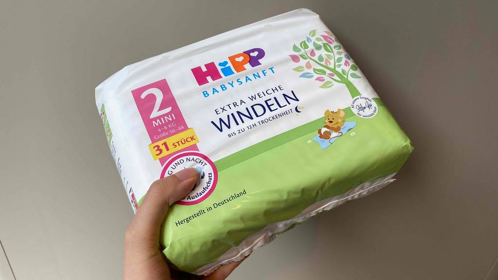 Windeln im Test: Eine Hand hält eine Packung Windeln vor hellen Hintergrund