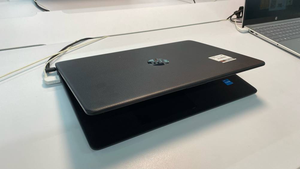 Ein getestetes HP-Laptop liegt leicht geöffnet auf einer weißen Fläche.